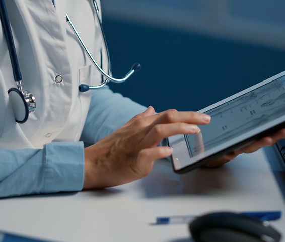 Clinician reviewing healthcare information on a tablet in a downstream workflow setting.
